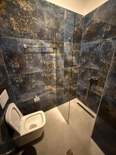 a bathroom with a toilet and a glass shower at Submarine 105 Rooms in Gjirokastër