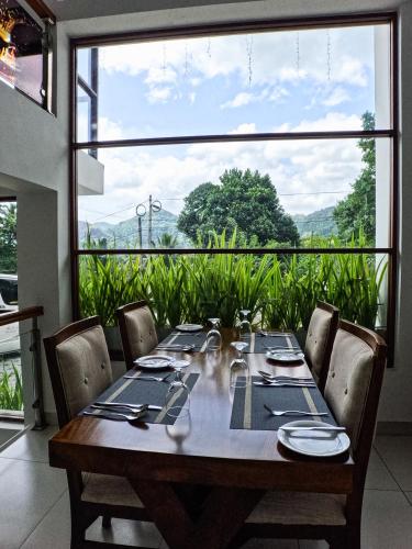 a dining room table with chairs and a large window at Royal Lion Hotel - Kandy Road, Galagadara in Galagedara