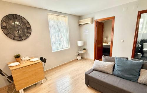 a living room with a couch and a clock on the wall at Vive Zaragoza XV in Zaragoza