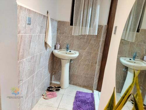 a bathroom with a sink and two toilets at 1 bedroom suite Diani in Ukunda Airport