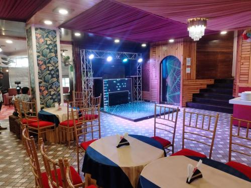 a set up for a party with tables and a stage at Hotel Rajmahal Inn in Gurgaon