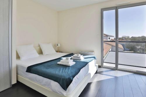 une chambre avec un grand lit et une grande fenêtre dans l'établissement Villa du Moulineau, à Les Sables-dʼOlonne