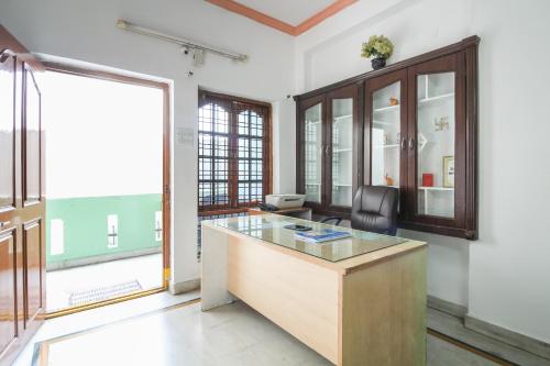 an office with a desk and a chair and a window at Hotel O Krupa Service Apartments in Hyderabad