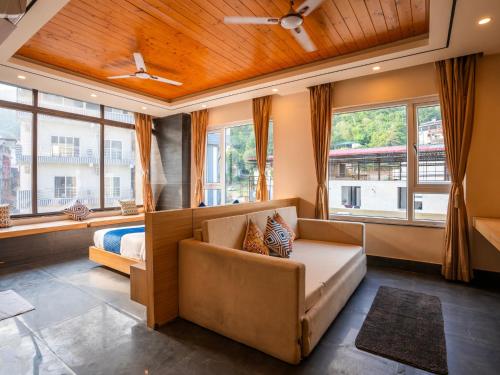 a room with a couch and a bed and windows at Moustache Select Rishikesh in Rishīkesh