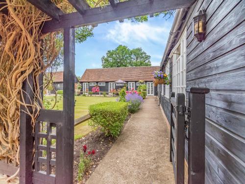 a carriage house with a fence and a yard at Weston Cottage - Uk50016 in Send