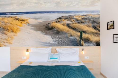 a bedroom with a bed with a painting of a beach at Hotel Bethanien in Langeoog
