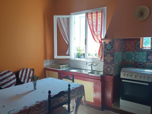 a kitchen with a table and a sink and a window at Περγαμόντο in Chios