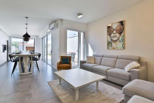 un salon avec un canapé et une table dans l'établissement Luxury villa with pool, à Les Sables-dʼOlonne