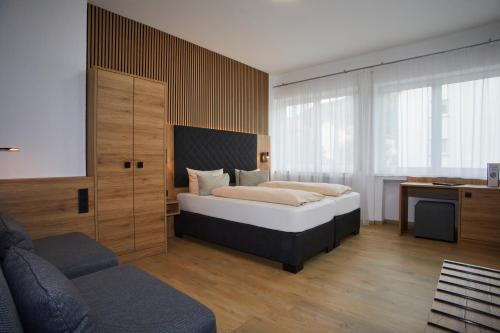 a bedroom with a bed and a couch at Hotel Rosenstein in Heubach
