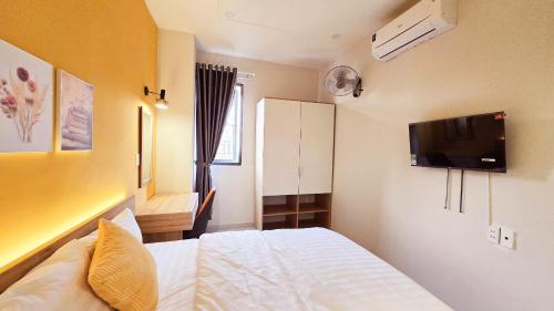 Un dormitorio con una cama y un televisor en la pared. en B House, en Ho Chi Minh