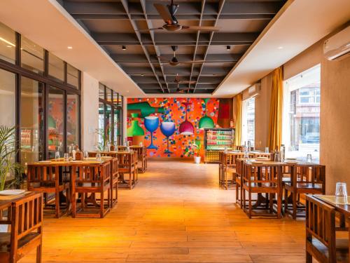 a dining room with wooden tables and chairs at Moustache Select Rishikesh in Rishīkesh