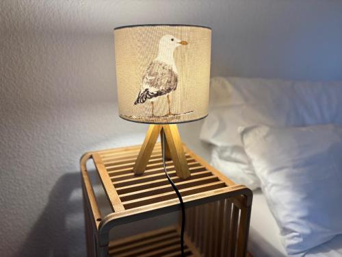 a lamp with a bird on top of a bed at Hotel Bethanien in Langeoog