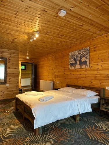 a bedroom with two beds in a wooden room at Hecaș Villas in Caşoca