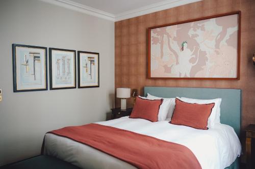 une chambre avec un grand lit avec des oreillers rouges dans l'établissement Maison Orphée, à Paris