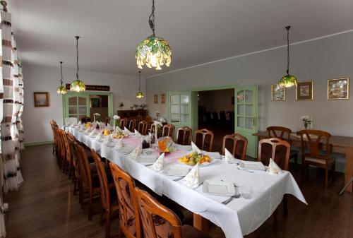 a long dining room with a long table and chairs at Hotel Sowa in Elblag