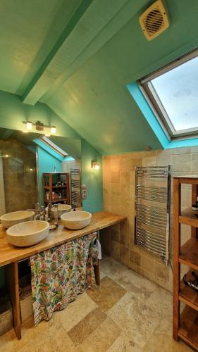 a bathroom with three sinks and a large mirror at House, Pool and Mountains in Myans