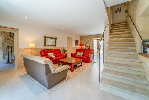 a living room with a red couch and stairs at Maison d'hôte - La Colline in Solérieux