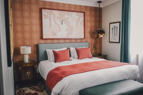 Un dormitorio con una cama grande con almohadas rojas. en Maison Orphée, en París