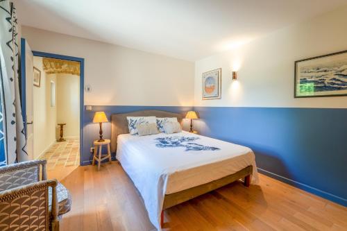 a bedroom with a large bed with blue walls at Maison d'hôte - La Colline in Solérieux