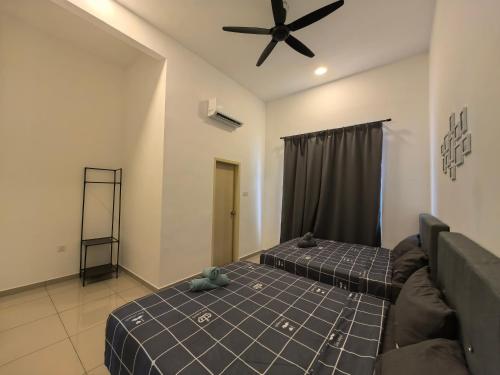 a bedroom with two beds and a ceiling fan at Padang Serai Wangi Homestay 95 in Padang Serai
