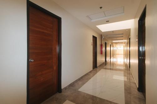 a hallway with a wooden door and a hallway with corridermottermottermott at RedDoorz @ Washington Guest House Olongapo in Olongapo