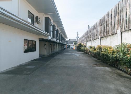 an empty alleyway between two buildings with bushes at RedDoorz @ Washington Guest House Olongapo in Olongapo