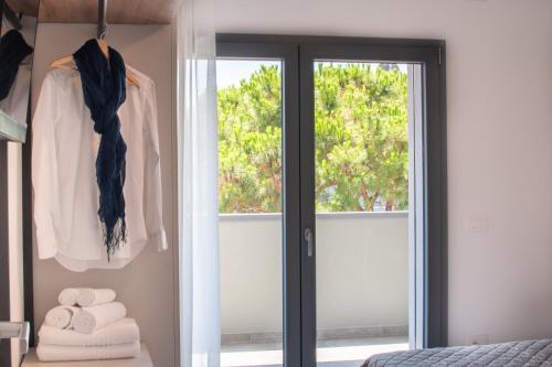 a bedroom with a sliding glass door and towels at One Life Suites in Bibione