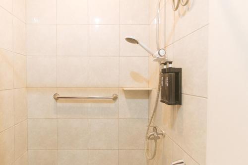 a shower with a shower head in a bathroom at RedDoorz @ Washington Guest House Olongapo in Olongapo