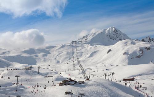 a snow covered mountain with a ski lift at Hôtel Club mmv Les Mélèzes **** in Arc 2000