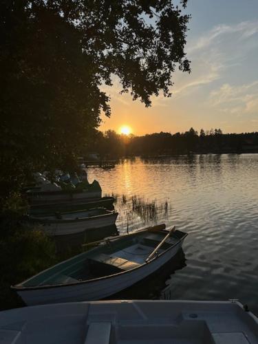a boat sitting on the water with the sunset in the background at Romantic apartment in Ruciane in Ruciane-Nida