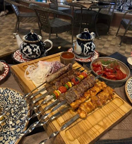 a table with meat and skewers on a cutting board at People Tours Bukhara in Muruntau