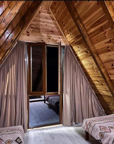 a attic room with a large window in a cabin at Village house Gutovic in Rudinice