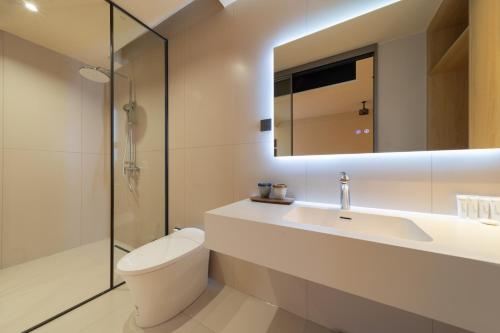 a bathroom with a toilet and a sink and a mirror at Warm Shore in Taiping