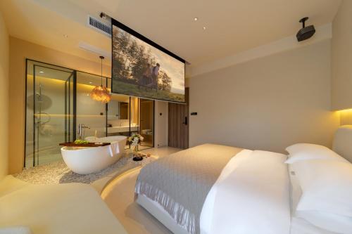 a bedroom with a large bed and a bath tub at Warm Shore in Taiping