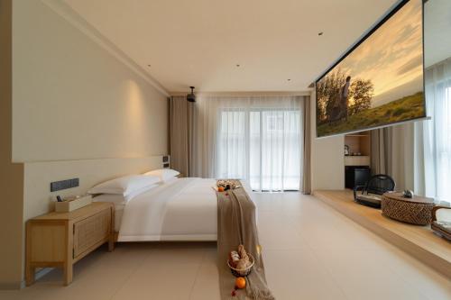a bedroom with a bed and a large painting on the wall at Warm Shore in Taiping