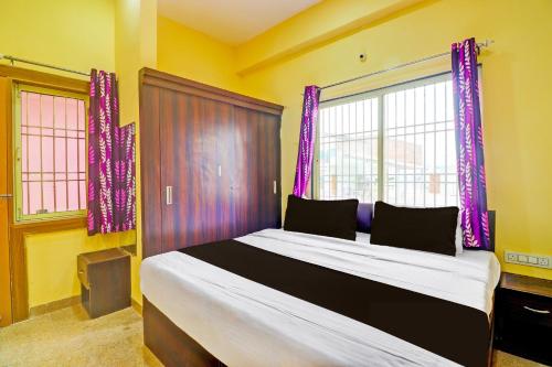 a bedroom with a large bed with purple curtains at Hotel O Heaven Inn in Gwalior