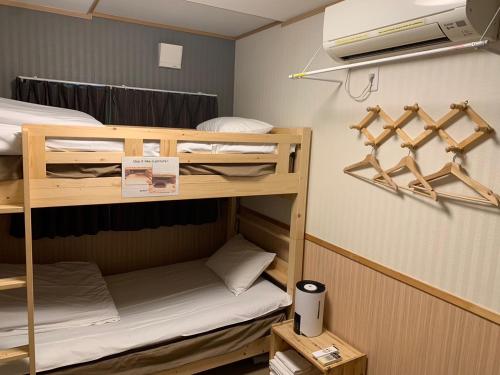 a small room with bunk beds and a tv at GuestHouse Guu in Fujikawaguchiko