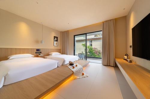 a bedroom with two beds and a flat screen tv at Warm Shore in Taiping