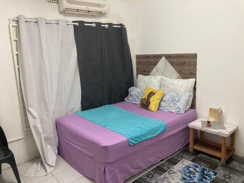 a bedroom with a purple bed with a black curtain at Home Choice in Maun