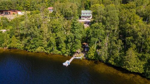 an aerial view of a house on a island in the water at Lake and Pool Table - Au Pied du Lac in Labelle