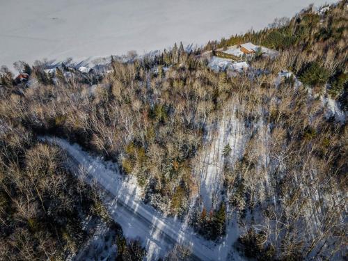 an aerial view of a mountain with trees and a house at Lake and Pool Table - Au Pied du Lac in Labelle