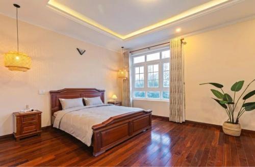 a bedroom with a bed and a large window at Tiên Hoa Sơn Villa in Da Lat