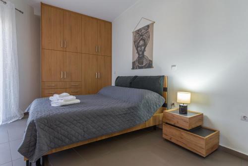 ナフパクトスにあるBill's Apartmentのベッドルーム(ベッド1台、木製キャビネット付)