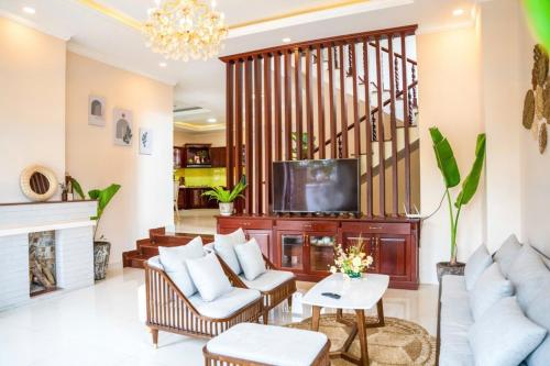 a living room with a couch and a tv at Tiên Hoa Sơn Villa in Da Lat