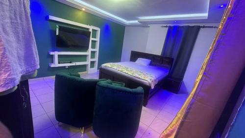 a bedroom with a bed and two chairs in a room at Mountains View Villa in Freetown
