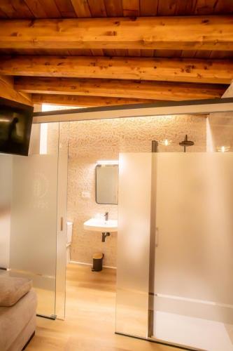 a glass door in a room with a wooden ceiling at HOSTAL BOUTIQUE CAZORLA BAKERY in Cazorla
