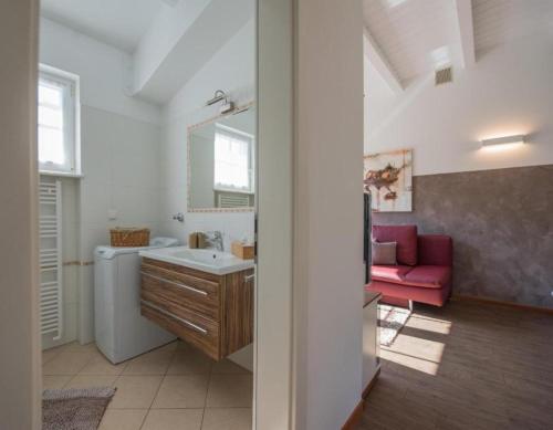 a bathroom with a sink and a red couch at Gartenhof in Brixen