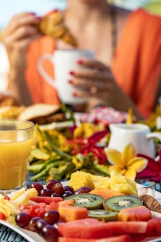 a plate of food with fruits and vegetables on a table at Hilton Moorea Lagoon Resort & Spa in Papetoai