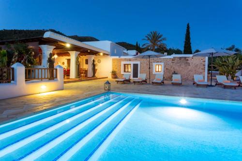 a villa with a swimming pool at night at Can Pep Den Sitges in Sant Joan de Labritja