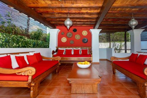 a living room with red couches and a table at Can Pep Den Sitges in Sant Joan de Labritja